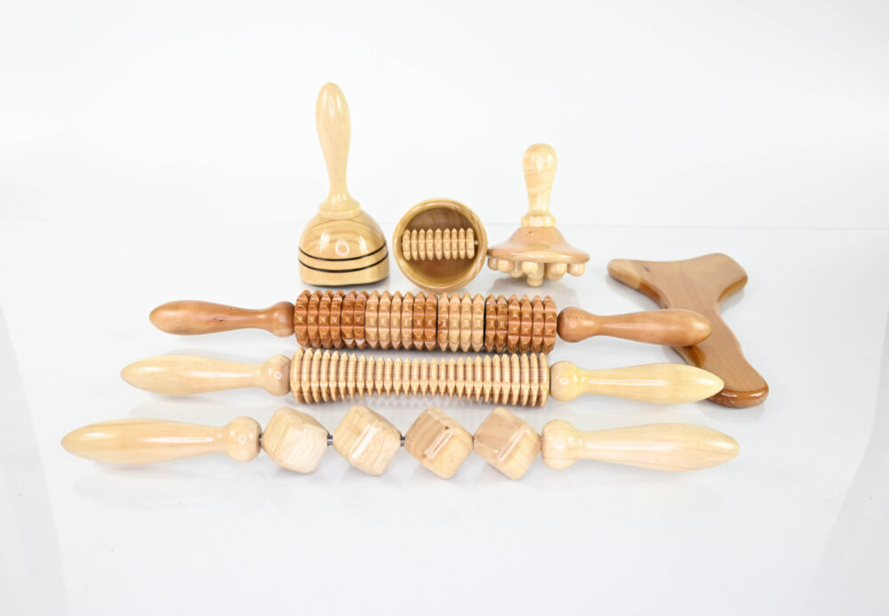 Set of Maderoterapia Corporal tools: 7 massagers, 3 rollers, 2 Swedish cups, 1 mushroom, 1 Gua Sha. Natural, smooth, varnished finish.