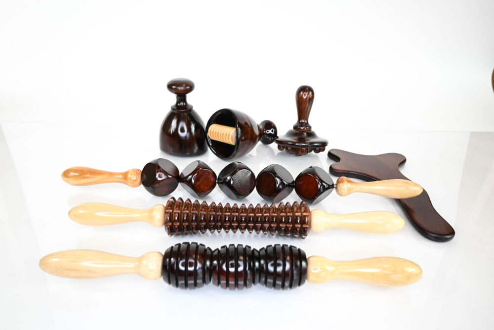 Best Wood Therapy Tools - Wooden Body Sculpting Tools kit of 7 pieces, including 3 rollers, 2 cups, 1 gua sha, and a fingered massager, all in dark brown pine wood. Ideal for breaking down fat, cellulite, fibrosis, lymphatic drainage, deep tissue massage, and muscle scraping.