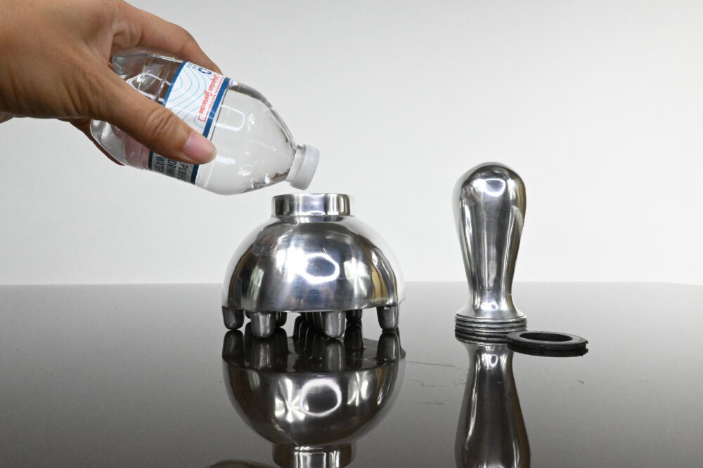 Demonstration of water being poured into an aluminum metal therapy mushroom tool, preparing it for Ice Body Sculpting and cellulite treatment.