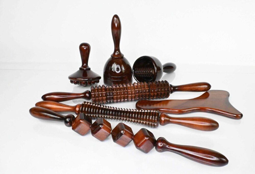 Professional wooden massage therapy tools arranged on a white background, ideal for body sculpting and lymphatic drainage.