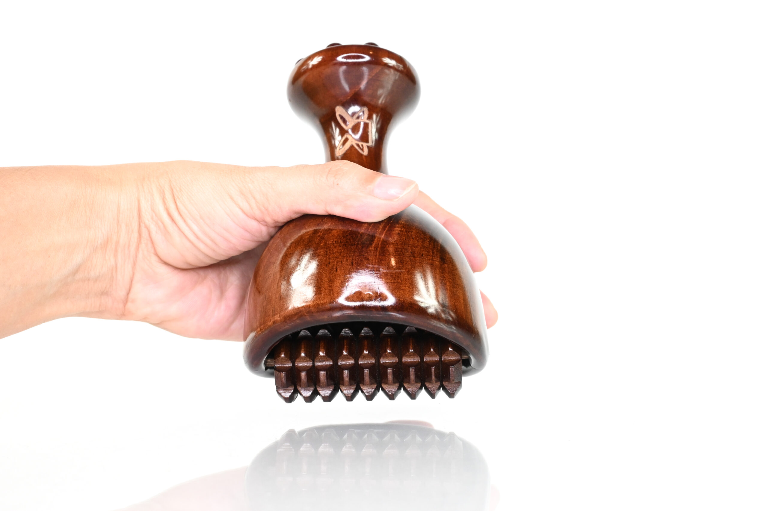 Hand holding lightweight maderoterapia cup with cob roller