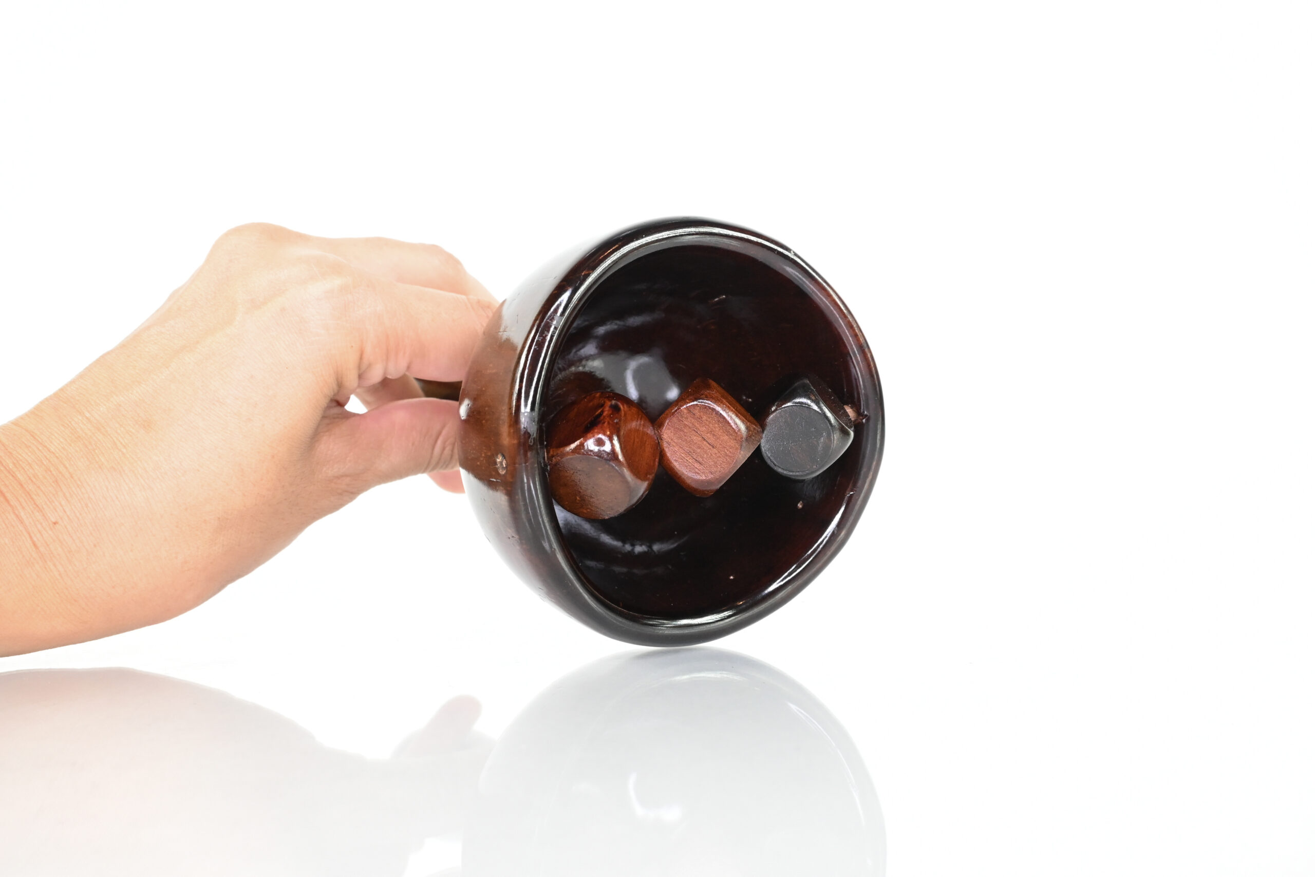 Three small cube rollers inside wooden Swedish cup