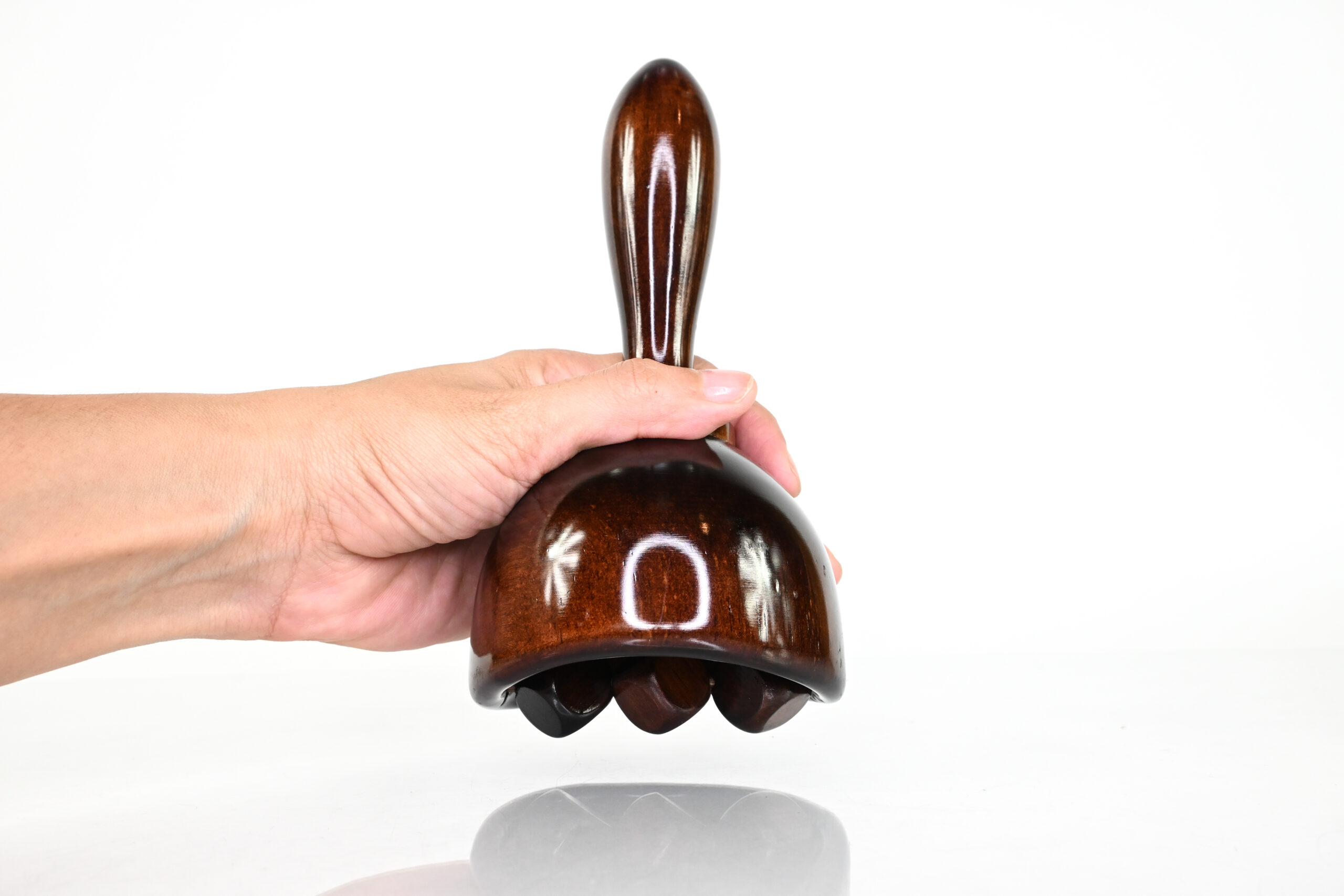 Hand holding wood therapy cube roller with Swedish cup
