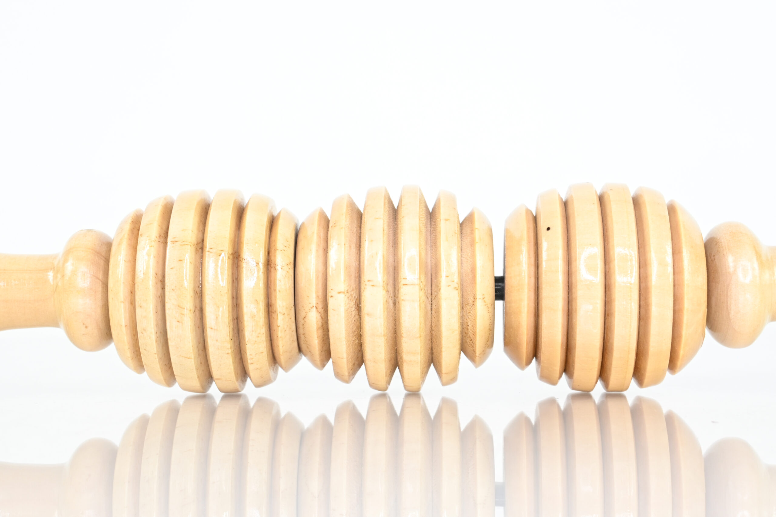 Close-up of three rounded sections on a soft wooden massage roller