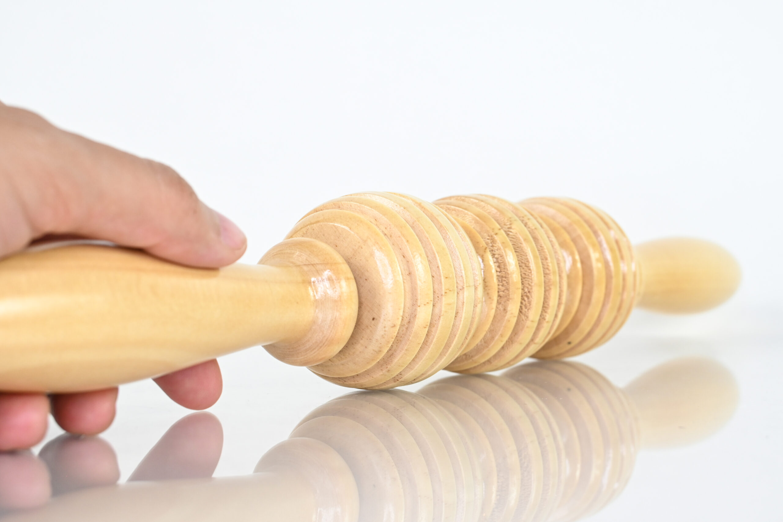 Three balls soft maderoterapia roller held by its wooden handle