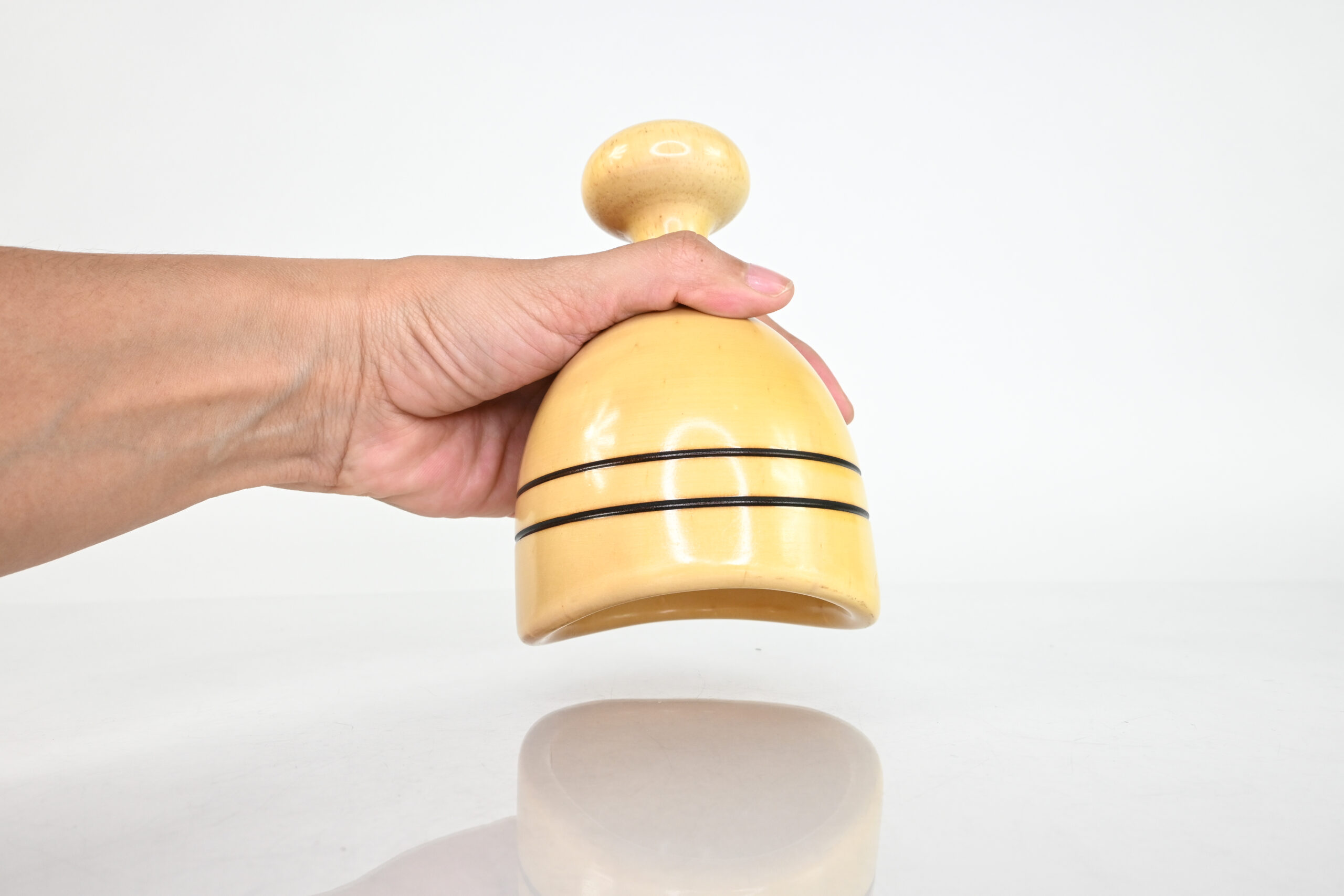Hand holding short-handle Swedish wood therapy cup